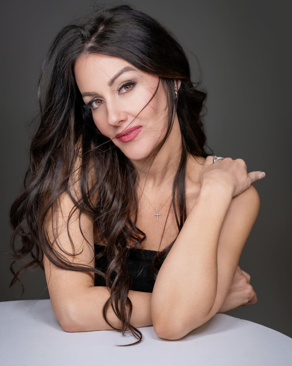 Beauty portrait in a black top against a charcoal backdrop